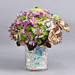 باقة ورد وردي وأخضر مع أنتوريوم ذهبي في فازة كريستالية